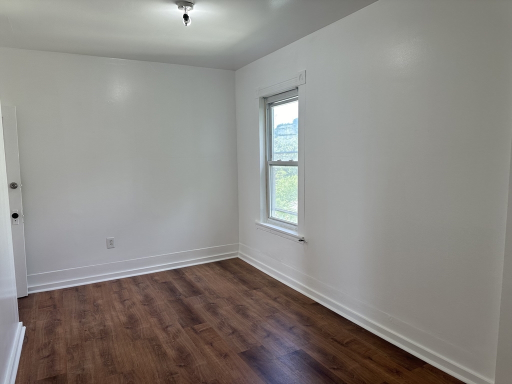 14 Hooper Street, Unit 3 Worcester, MA 01605 - Photo 7 of 12 an empty room with wooden floor and windows