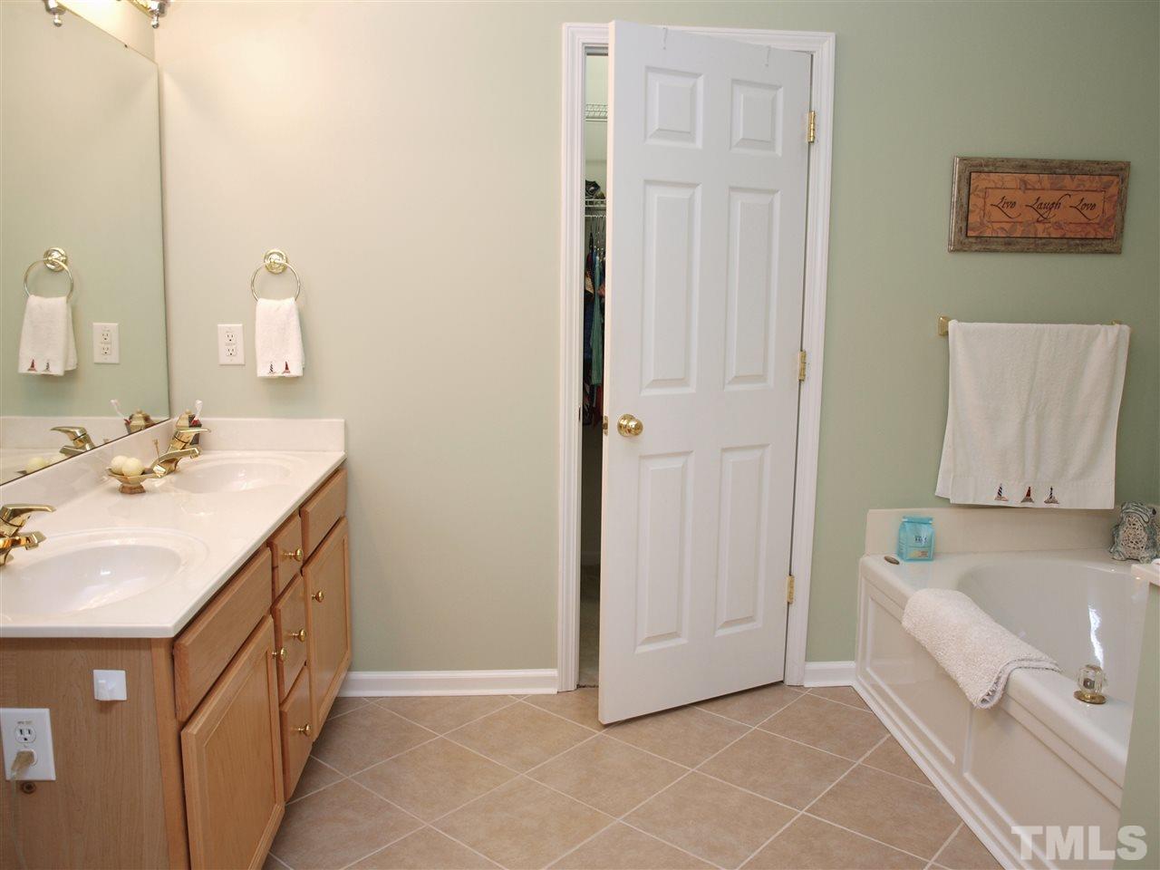 10465 Dapping Drive Raleigh, NC 27614 - Photo 10 of 19 a bathroom with a double vanity sink a mirror and a bathtub