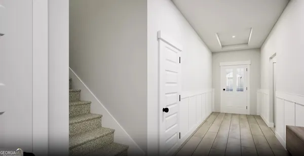 a view of a hallway with wooden floor and entryway