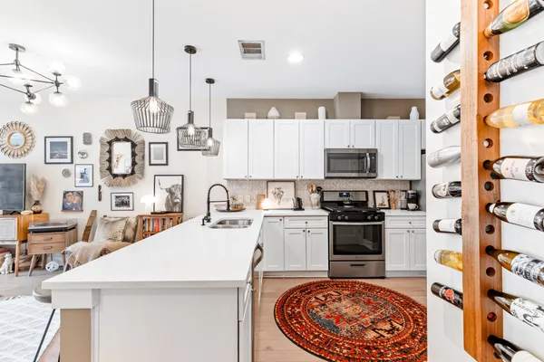 a kitchen with stainless steel appliances granite countertop a sink a stove and cabinets