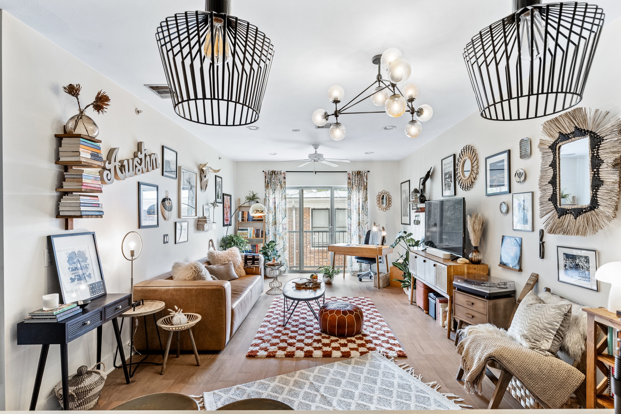 908 Nueces Street, Unit 24 Austin, TX 78701 - Photo 12 of 39 An open, spacious living area bathed in natural light, highlighted by custom light fixtures and wood floors.