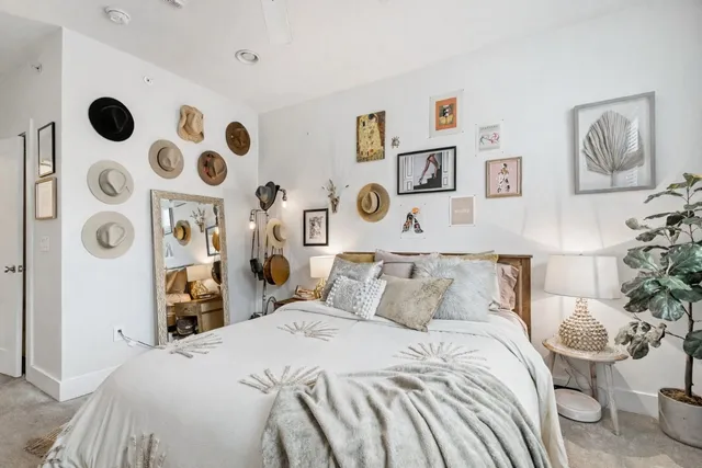 a bedroom with a bed and painting on the wall