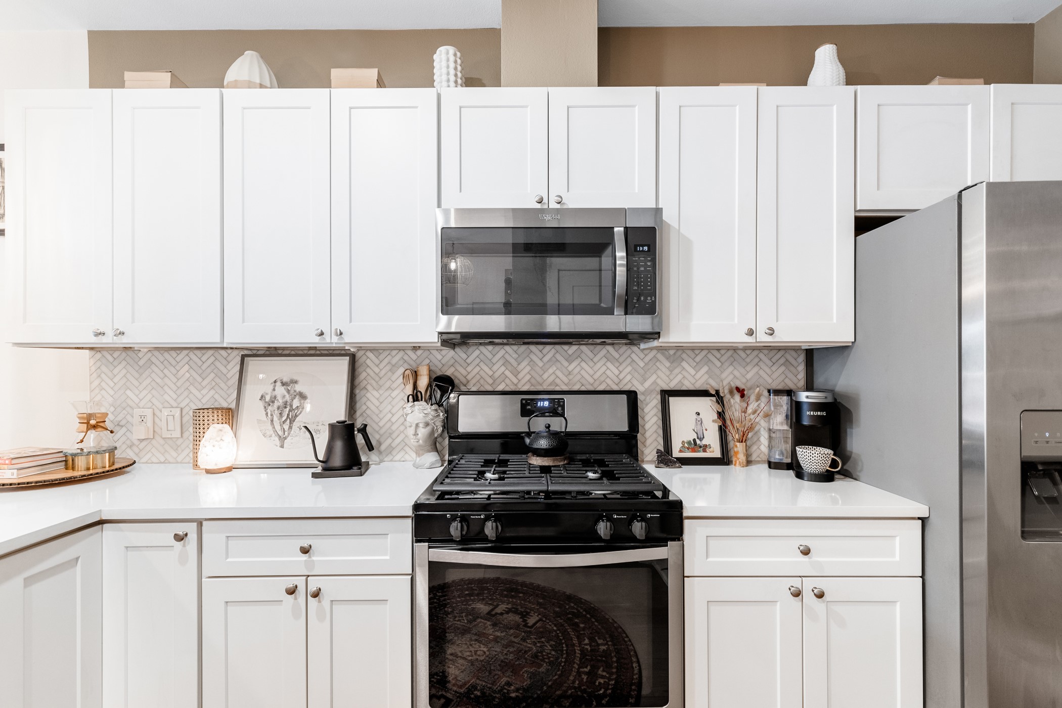 908 Nueces Street, Unit 24 Austin, TX 78701 - Photo 4 of 39 Bright white kitchen featuring a beautiful backsplash, stainless steel appliances, and a stackable washer/dryer