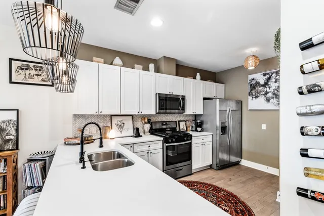 a kitchen with stainless steel appliances granite countertop a sink stove and refrigerator