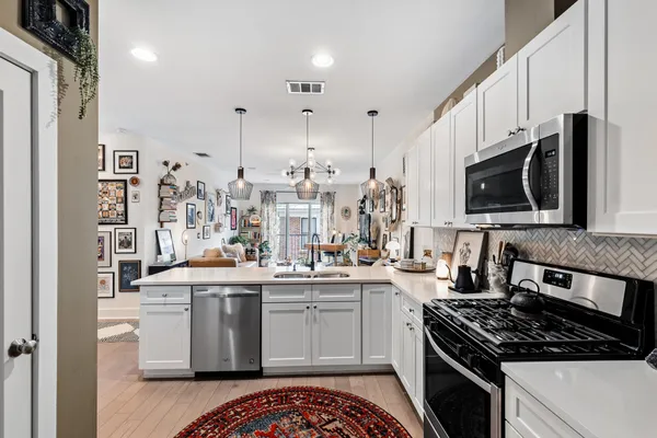 a large kitchen with cabinets and a wooden floor