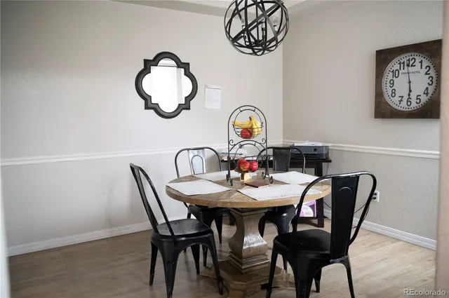 a view of a dining room with furniture a chandelier and wooden floor