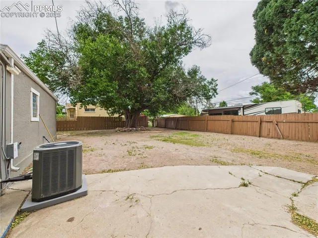 a view of backyard space with wooden fence