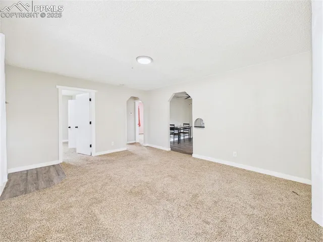 a view of empty room with kitchen