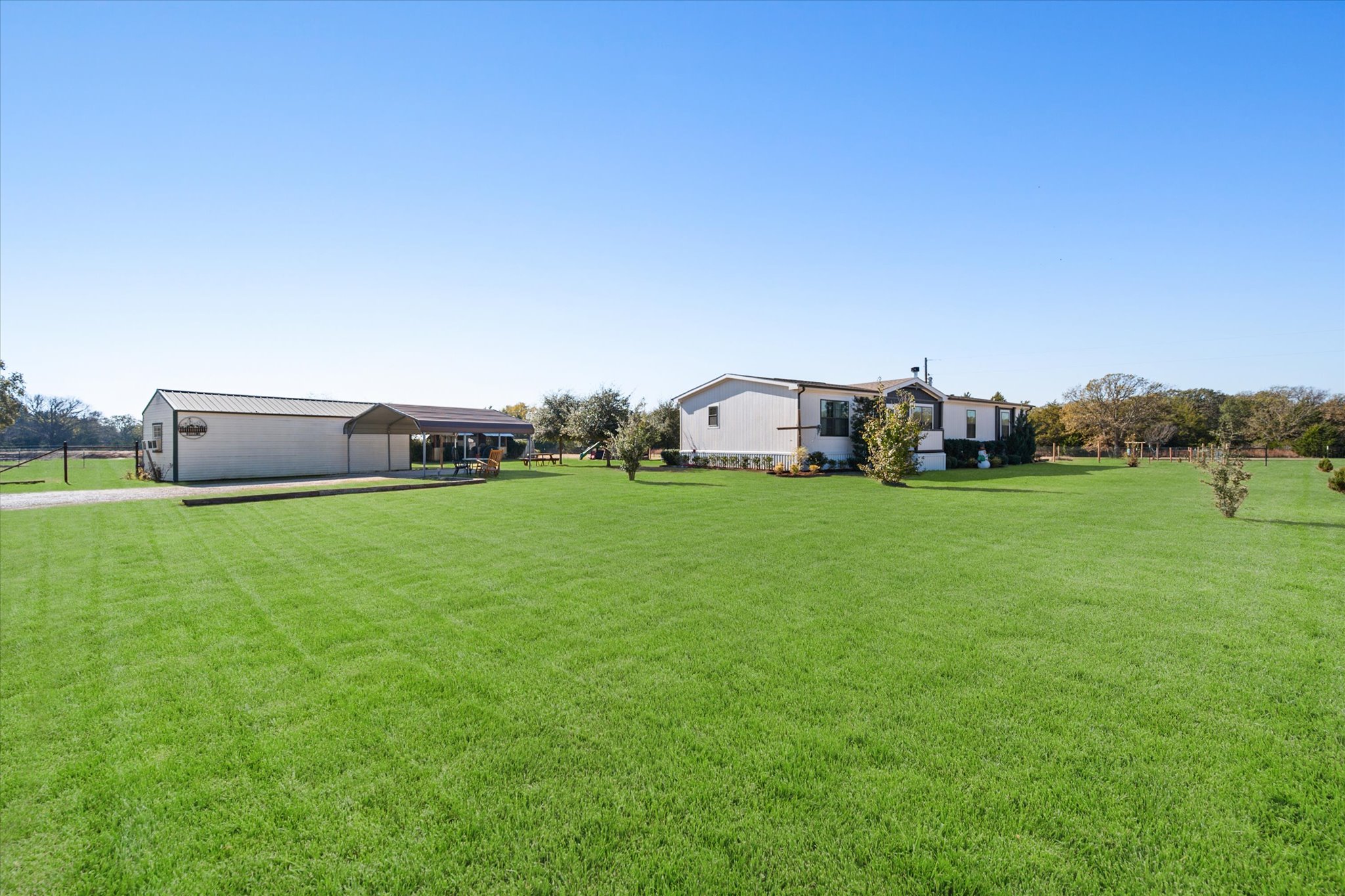 16857 Fm 639 Road East Purdon, TX 76679 - Photo 9 of 38 View of green lawn with an outbuilding, a carport, and a pole building
