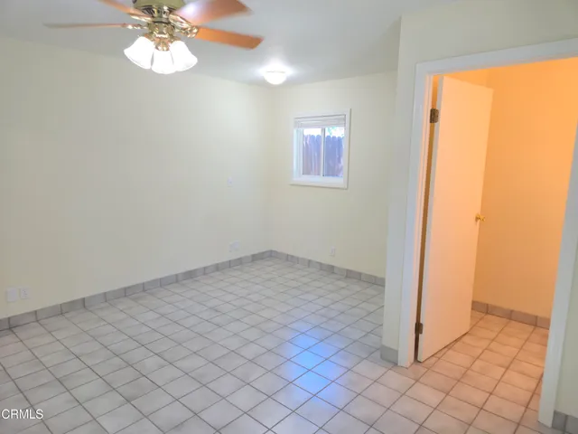 an empty room with a chandelier fan