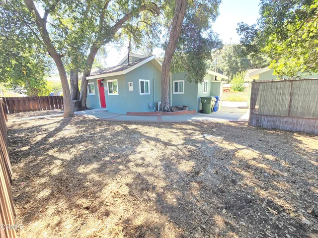 a view of a yard with a house and a large tree