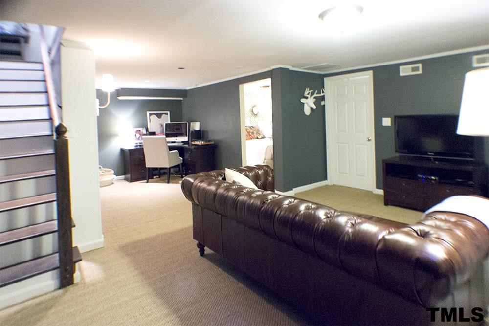 2216 Alexander Road Raleigh, NC 27608 - Photo 18 of 24 a living room with furniture and a flat screen tv