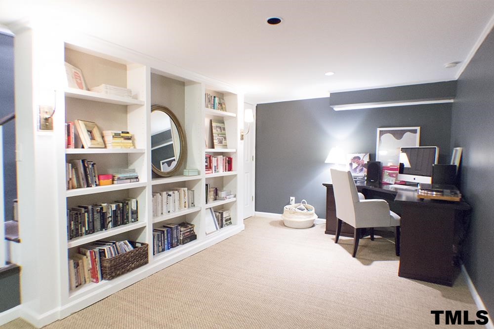 2216 Alexander Road Raleigh, NC 27608 - Photo 19 of 24 a view of a workspace with furniture and a bookshelf