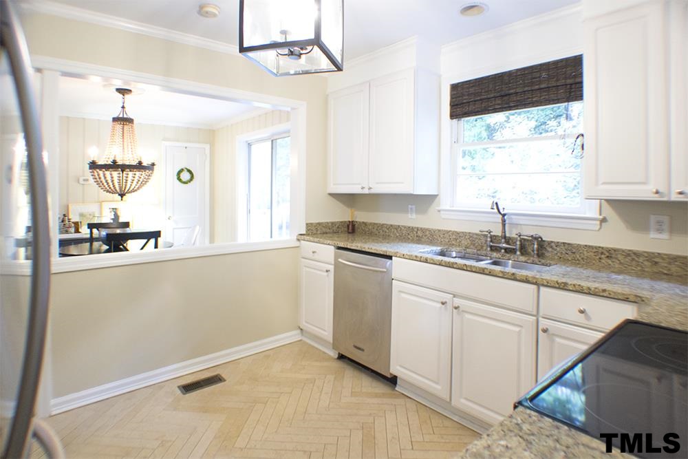 2216 Alexander Road Raleigh, NC 27608 - Photo 9 of 24 a kitchen with granite countertop white cabinets white appliances a sink and a window