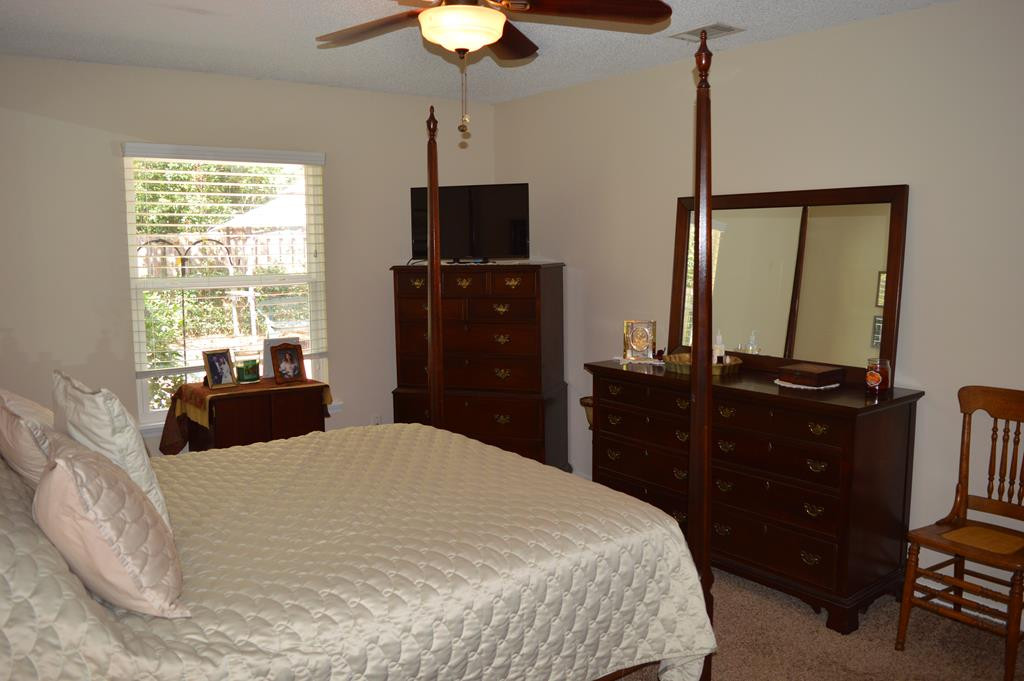 108 Raintree Court Aiken, SC 29803 - Photo 14 of 18 a bedroom with a bed and a flat tv screen on dresser