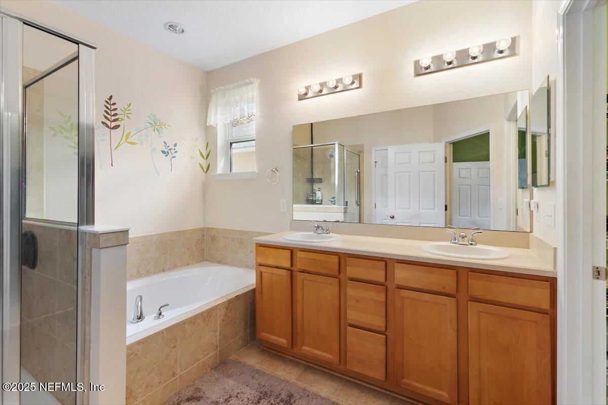38 Litke Lane St. Augustine, FL 32086 - Photo 4 of 27 a bathroom with a tub a double vanity sink and mirror
