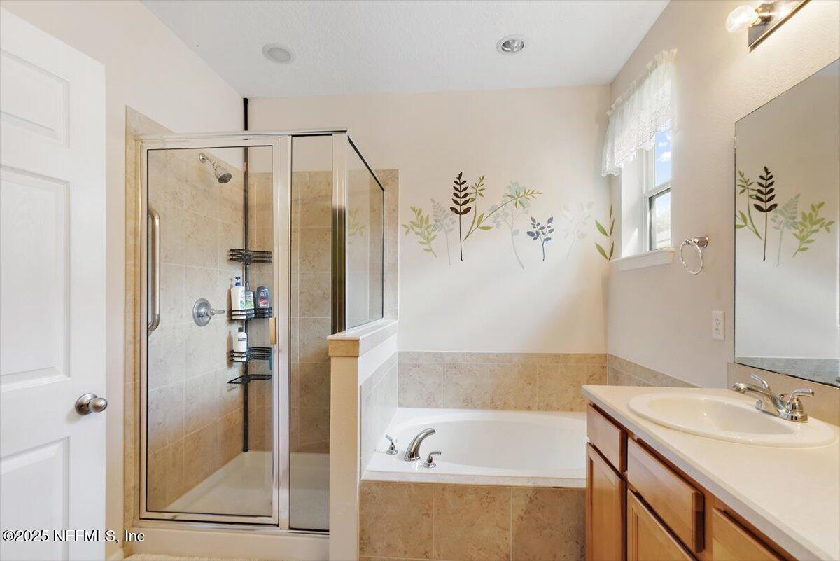 38 Litke Lane St. Augustine, FL 32086 - Photo 5 of 27 a bathroom with a tub a sink and glass door shower