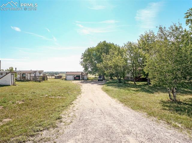 5805 Meridian Road Peyton, CO 80831 - Photo 2 of 22 Driveway into property with mature trees.