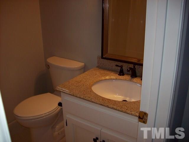 5904 Stable Court Raleigh, NC 27612 - Photo 12 of 16 a bathroom with a granite countertop toilet and a sink