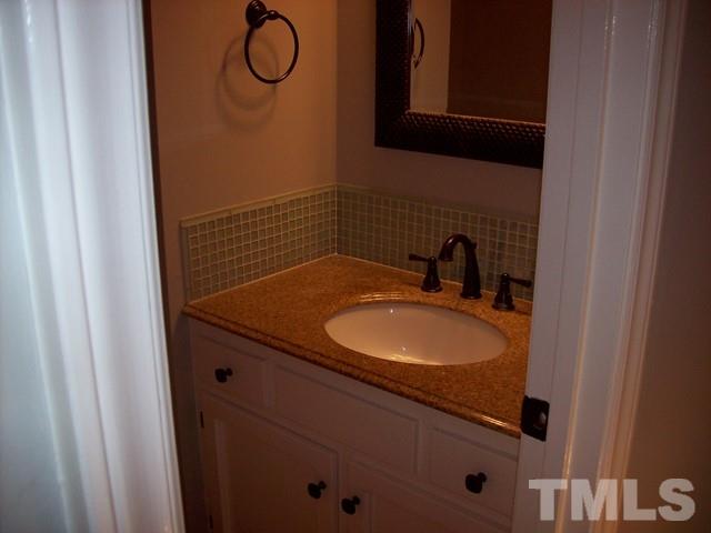 5904 Stable Court Raleigh, NC 27612 - Photo 13 of 16 a bathroom with a granite countertop sink and a mirror