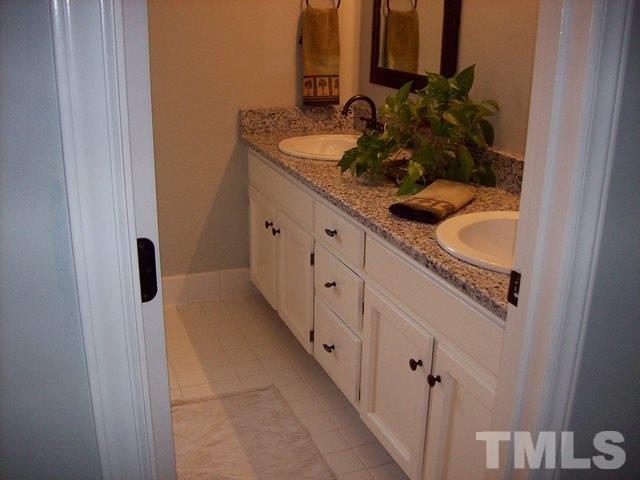 5904 Stable Court Raleigh, NC 27612 - Photo 9 of 16 a bathroom with a double vanity sink and mirror