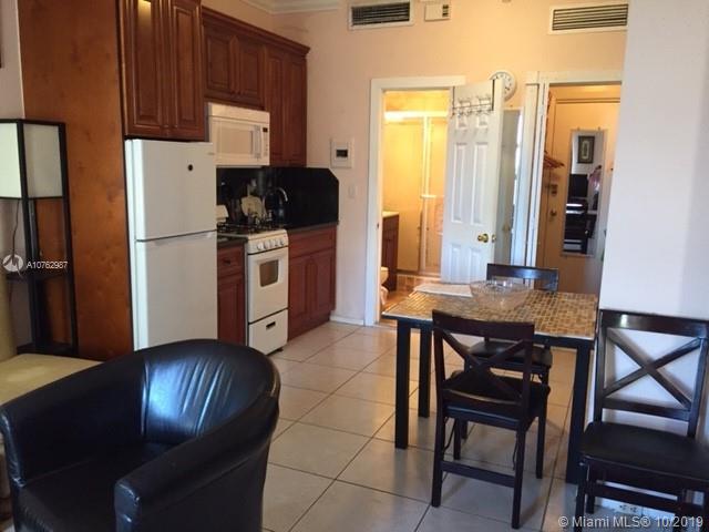 a kitchen with stainless steel appliances granite countertop a stove a refrigerator a table and chairs