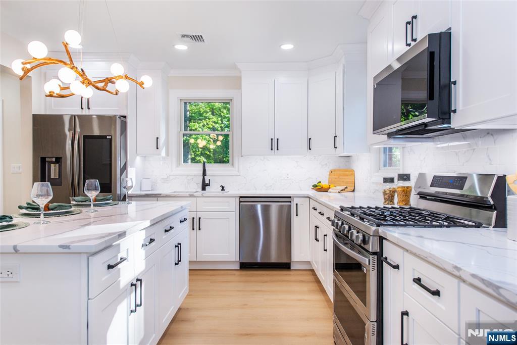 145 Grove Street Mahwah, NJ 07430 - Photo 11 of 30 a kitchen with stainless steel appliances granite countertop a stove a sink and a microwave