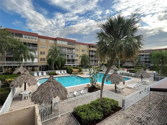 a view of a swimming pool with outdoor seating and a garden