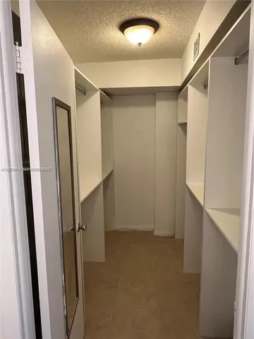 a bedroom with a balcony a bed and a walk in closet