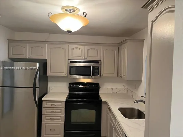 a kitchen with a refrigerator sink and microwave