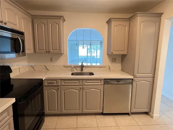 a kitchen with a sink cabinets and a microwave