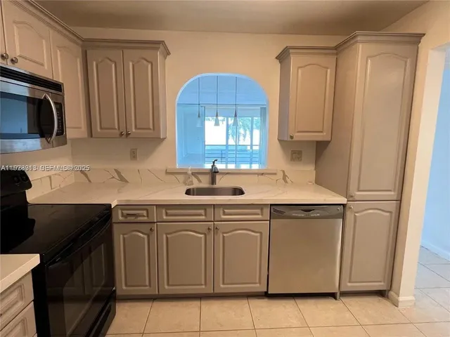 a kitchen with a sink cabinets and a microwave