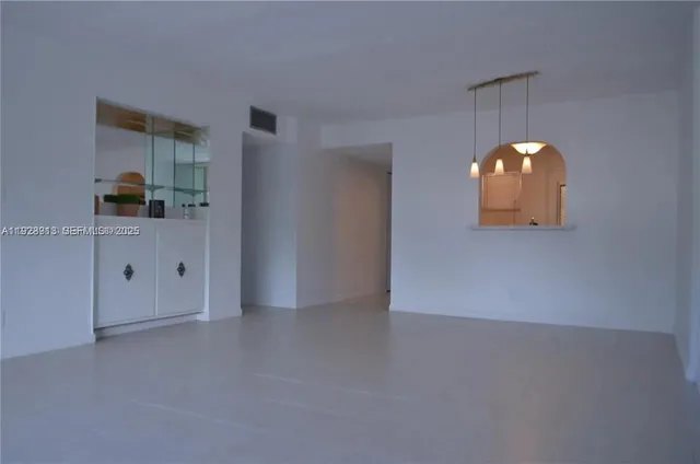 an empty room with wooden floor and cabinet