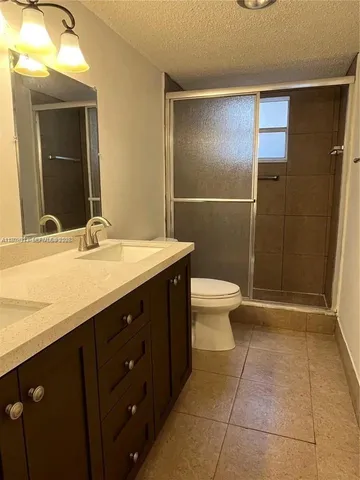 a bathroom with a sink a toilet a mirror and shower