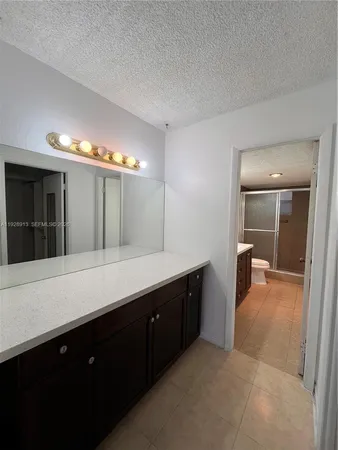 a spacious bathroom with a sink and a mirror