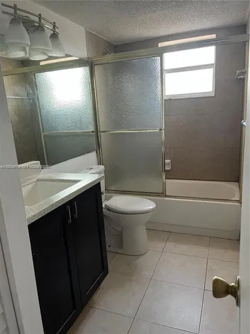 a bathroom with a sink a toilet a mirror and shower
