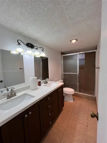 a bathroom with a double vanity sink toilet and mirror