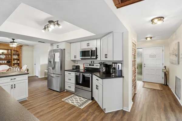 a kitchen with stainless steel appliances granite countertop a refrigerator stove top oven and sink