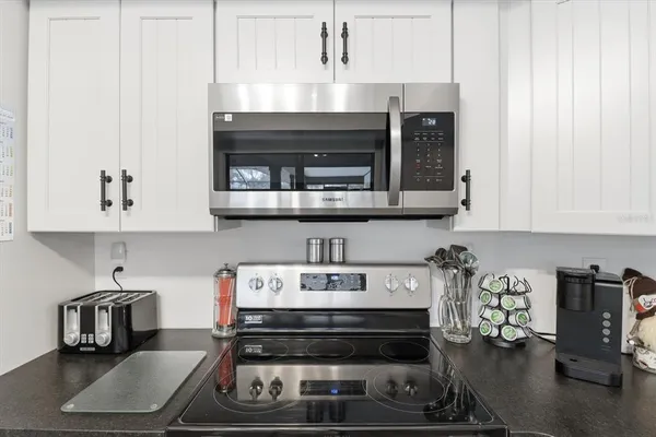 a kitchen with stainless steel appliances granite countertop a stove and a microwave