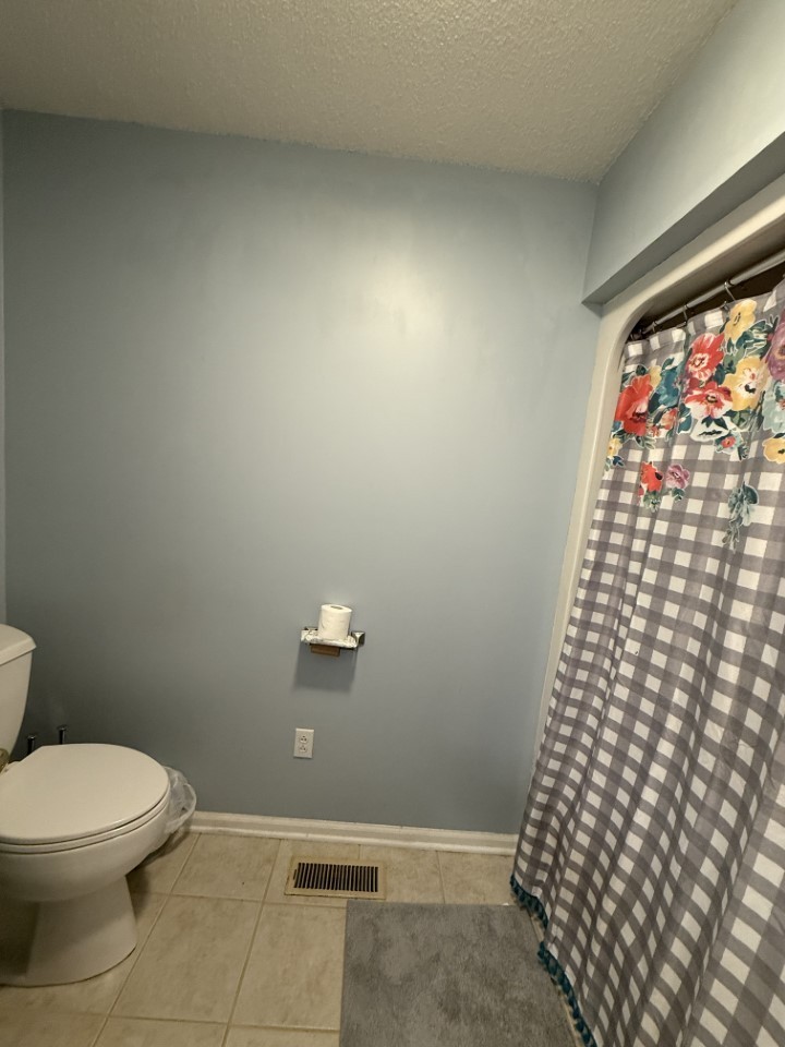 405 Robins Street Lawrenceburg, TN 38464 - Photo 23 of 65 a bathroom with a toilet and a shower curtain