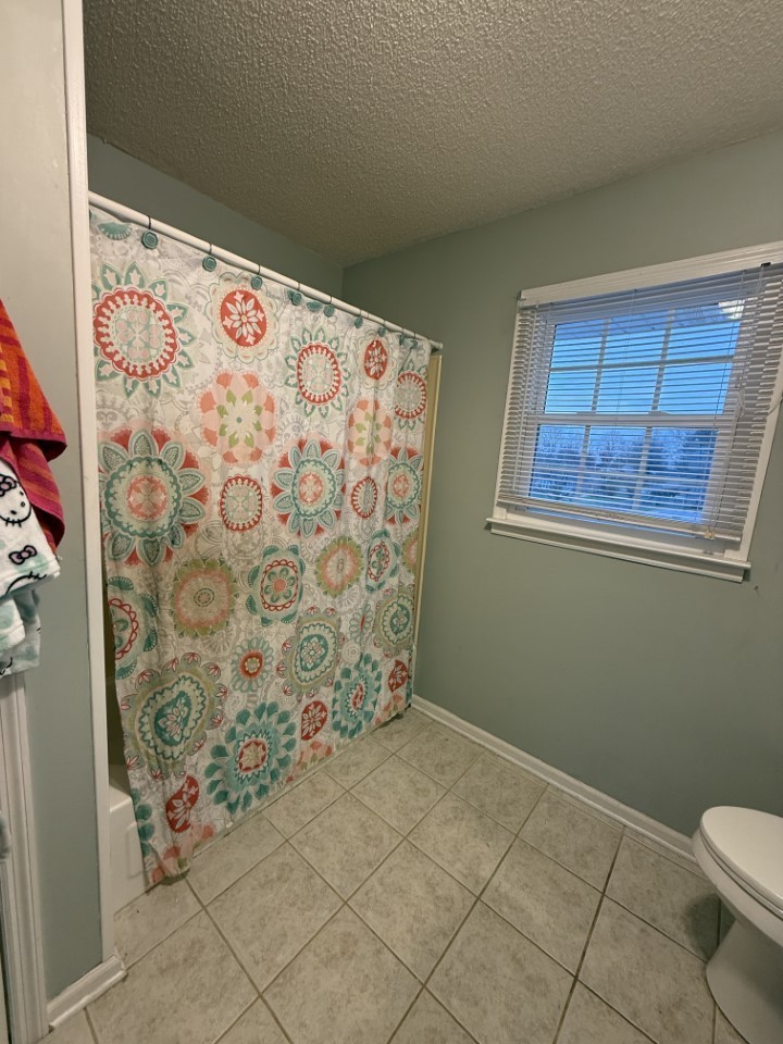 405 Robins Street Lawrenceburg, TN 38464 - Photo 29 of 65 a bathroom with a toilet and shower curtain