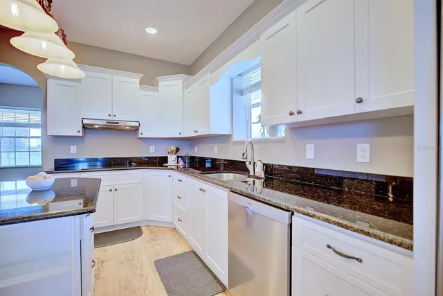 a kitchen with stainless steel appliances granite countertop a refrigerator and a stove