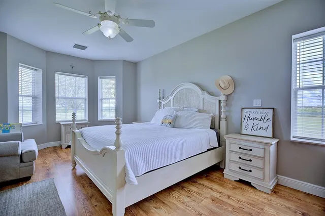 a bedroom with a bed a chandelier and dresser