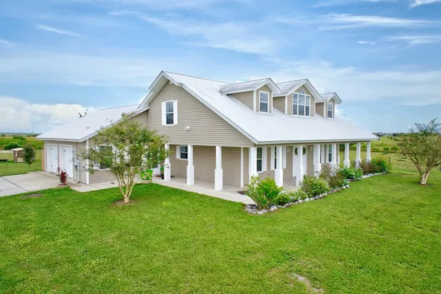a front view of a house with a garden and plants