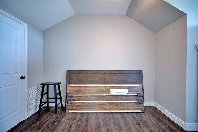 a view of room and hallway with wooden floor