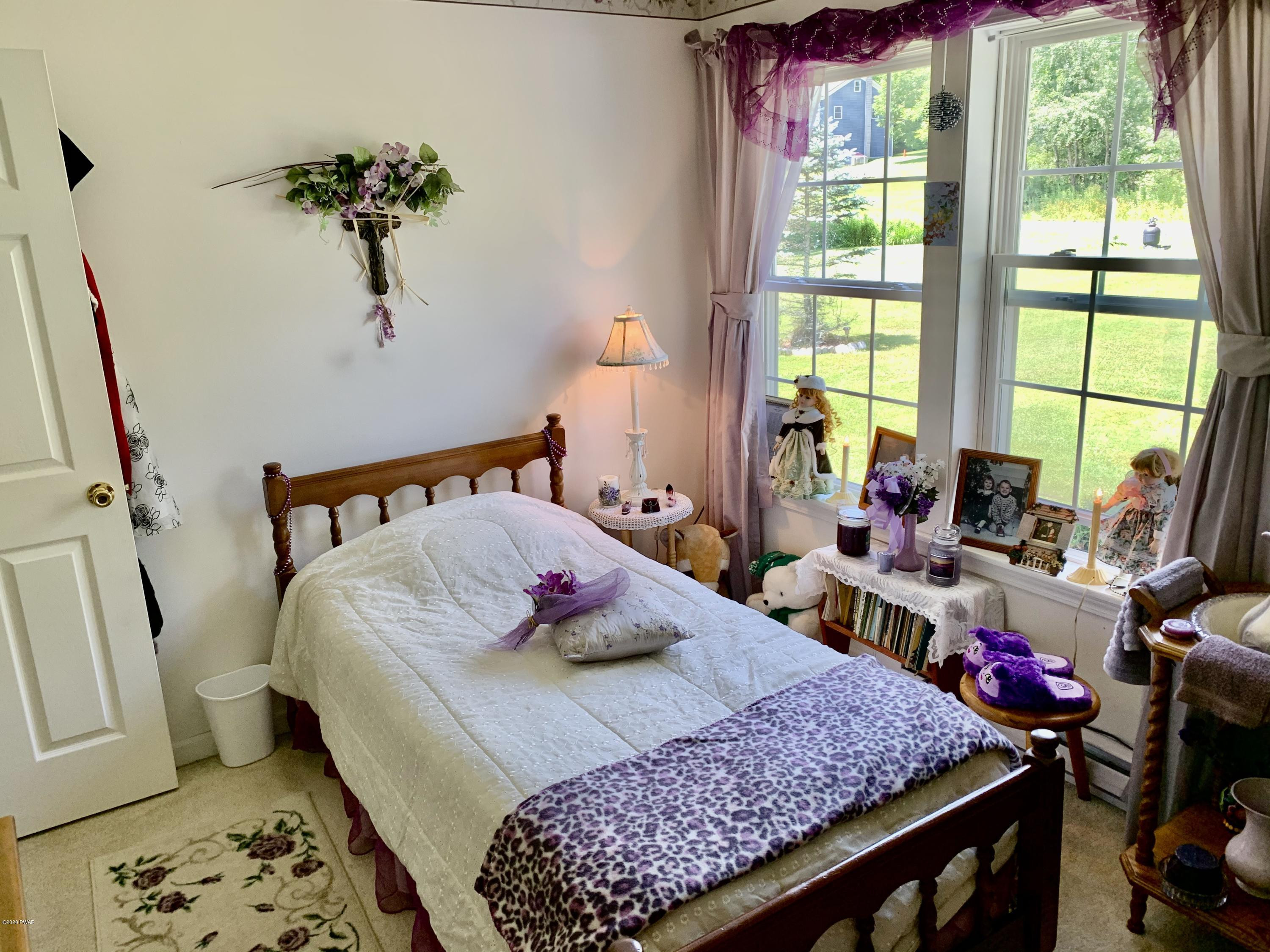 678 Stock Farm Road Lake Ariel, PA 18436 - Photo 33 of 41 a bedroom with a bed and wooden floor