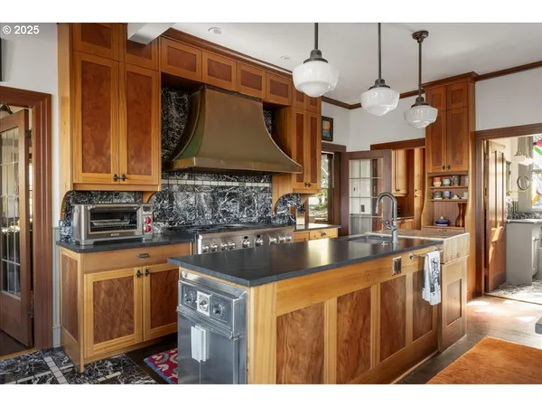 a kitchen with stainless steel appliances granite countertop a sink a stove and a microwave