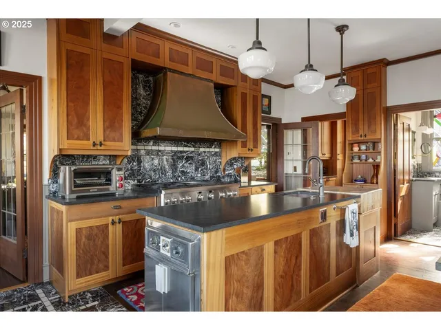a kitchen with stainless steel appliances granite countertop a sink a stove and a microwave