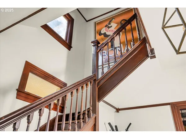 a view of staircase with a metal railing and a large window
