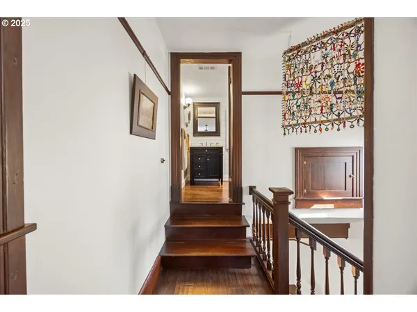 a view of a hallway with wooden floor and staircase